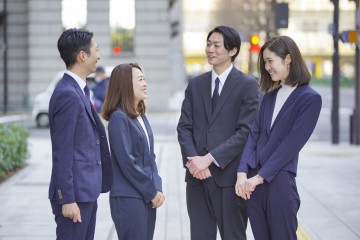 屋外にいるスーツ姿の男女